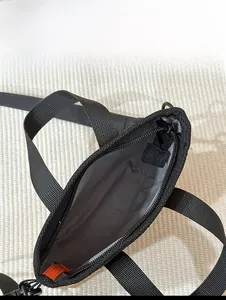 Innenraum-Kapazität der schwarzen Tasche mit grauem Futter und orangen Reißverschluss-Details