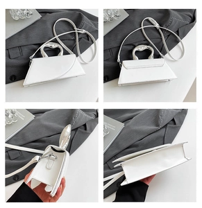 Vue macro d'un sac à main blanc en cuir avec une poignée métallique argentée ondulée