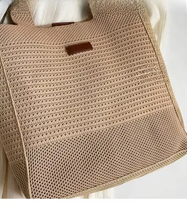 Close-up of beige woven tote bag showing hollow knit texture and brown leather patch