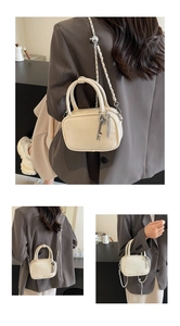 Dettagli mini borsa quadrata crema con ciondolo a chiave dorata e tracolla a catena