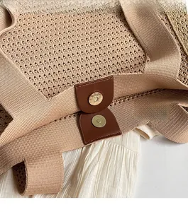 Detail of the magnetic buckle closure on a woven tote bag with leather reinforcement