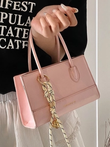 Rosafarbene rechteckige Lederhandtasche mit gewebtem Anhänger und doppelten Griffen