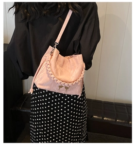 Detail of pink pleated bucket bag with braided handle and gold butterfly clasp