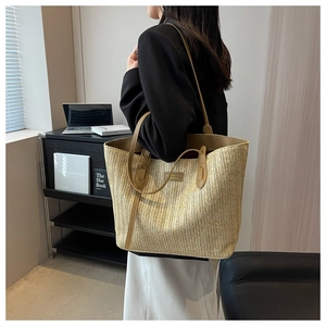 Lifestyle view of large woven tote bag with leather straps on a model in a modern office