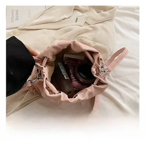 Top view of pink drawstring bucket bag showing interior space with cosmetics and spray bottle