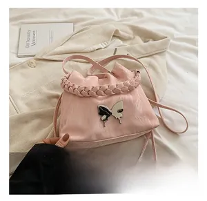 Pink pleated bucket bag with silver butterfly buckle and tweed woven handle detail