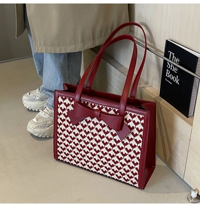 Detailed view of red bow decoration and heart pattern on the stylish tote bag