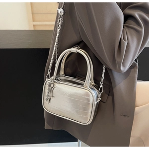 Dettaglio della borsa squadrata argento metallizzato con catena e ciondolo chiave