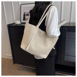 Close-up of lightweight woven tote bag with wavy texture and shoulder strap on model