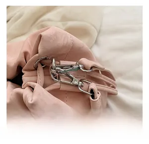 Detail view of the silver metal hook and fine stitching on the pink drawstring bucket bag