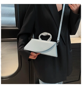 Détail du sac à main géométrique bleu clair avec poignée argentée fluide chic