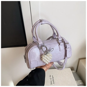 Detail of lavender wrinkled leather handbag with silver hardware and pearl heart charm