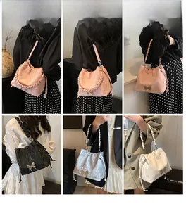 Detail of drawstring bucket bags featuring metallic bow accents and braided handles