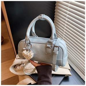 Detail of light blue pleated Boston bag with pearl heart charm and adjustable strap