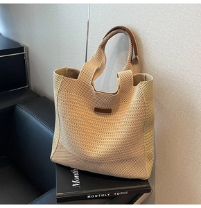 Detailed macro view of the woven tote bag featuring soft beige texture and leather handle