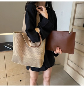 Close-up of woven tote bag with a small brown leather clutch inside for daily commute