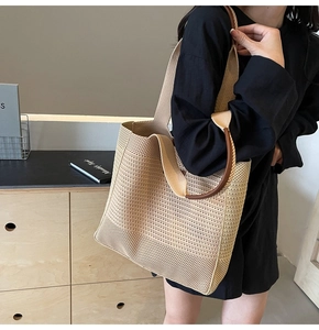 Close-up of woven net mesh texture with durable brown leather handles on a beige tote bag