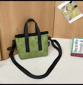 Detailansicht der grasgrünen Tyvek-Tasche mit Knitteroptik und schwarzem Schultergurt