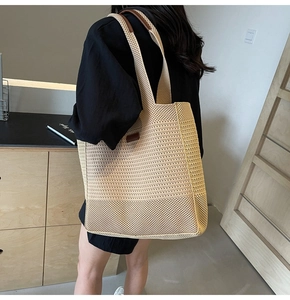 Detailed close-up of woven tote bag texture with brown leather logo patch and handle