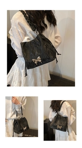 Detail of black pleated bucket bag with silver butterfly buckle and braided strap