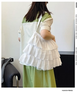 Close-up of a white tiered ruffle shoulder bag with lightweight layered chiffon fabric