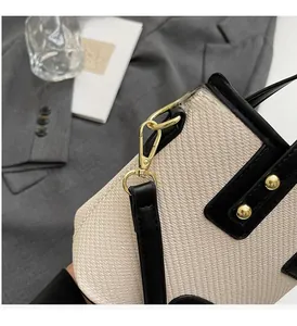 Gros plan sur le sac seau tissé avec garnitures dorées haut de gamme et détails en cuir