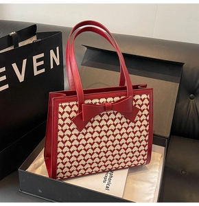 Macro shot of a red bow tote bag with heart pattern inside a luxury gift box packaging