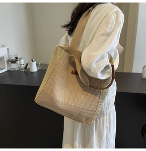 Detail showing the side view of a large woven tote bag in gradient beige knit fabric