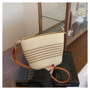 Dettaglio della borsa a secchiello in paglia bohémien con strisce beige e marroni