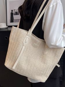Women large cream woven tote bag with leather straps and logo patch shown on shoulder