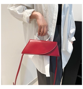 Détail du sac à main rouge en cuir avec sa poignée métallique argentée irrégulière