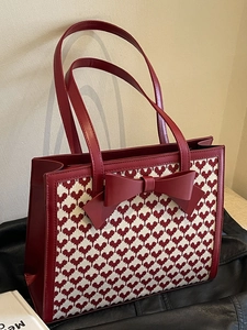 Elegant red heart woven tote bag with large leather bow and dual handles in 45-degree view
