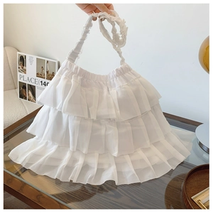 Detailed close-up of a white layered ruffle handbag made of light translucent mesh fabric