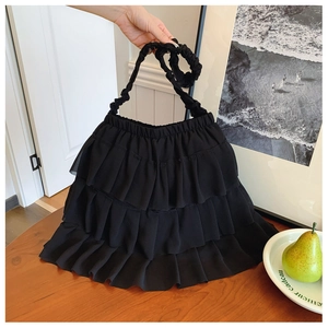 Detail of black tiered ruffle tote bag featuring triple-layered chiffon and pleated strap