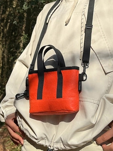 Minimalistische orangefarbene Umhängetasche aus DuPont-Papier mit schwarzen Gurten