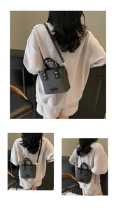 Détail de la texture tissée et des finitions dorées d'un sac seau noir pour femmes