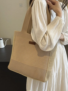 Woven straw tote bag in beige with leather detail, styled with a casual summer white dress
