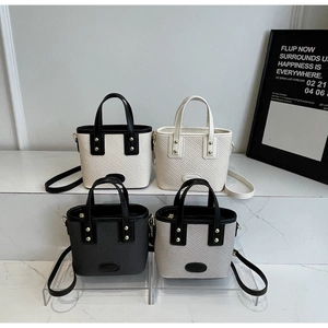 Détail de mini sacs seaux en quatre couleurs avec rivets dorés et texture en cuir