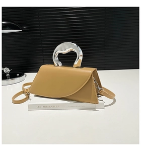 Détail de la poignée en métal argenté d'un sac à main carré en cuir kaki pour femme