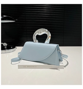 Détail du sac bandoulière bleu clair avec une poignée métallique argentée moderne
