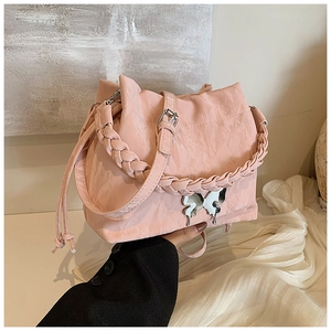 Close-up of pink bucket bag with pleated texture and metallic butterfly buckle