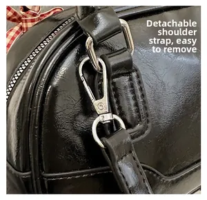 Detail of silver metal hook and D-ring on black PU leather Boston bag with strap