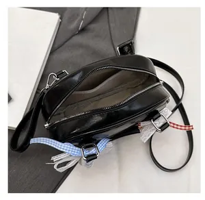 Macro view of black glossy leather bag interior with neat inner pocket and ribbon