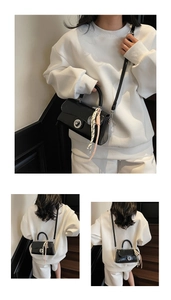 Détail d'un sac à main noir brillant avec boucle ronde en métal et foulard en soie