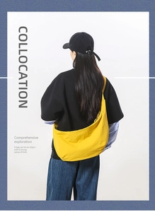 Close-up of yellow nylon crescent bag with wide shoulder strap worn in a casual street style