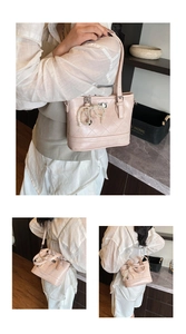 Detail of light pink quilted bucket bag with pearl bow charm and silver twist lock