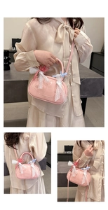Close-up of pink Boston bag with lace trim, plaid bows and adjustable shoulder strap