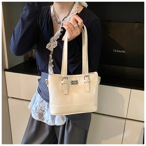 Detailed view of cream quilted bucket bag with silver turn-lock and leather texture