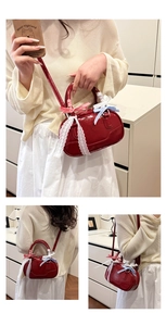 Detail view of red patent leather Boston bag with decorative bows and lace trim