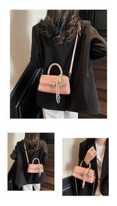 Pink leather square handbag detail with silver buckle and black white striped scarf accessory